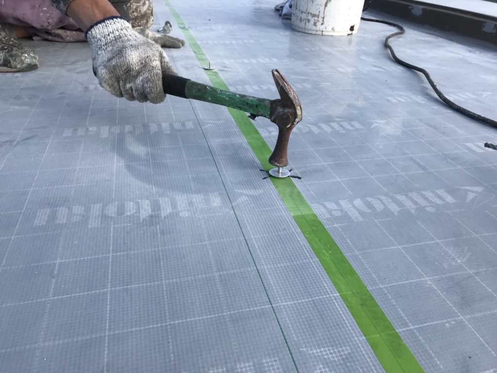 強風などで飛ばされないために硬質断熱材とタックシートをメカニカルアンカーピンでしっかり固定します。